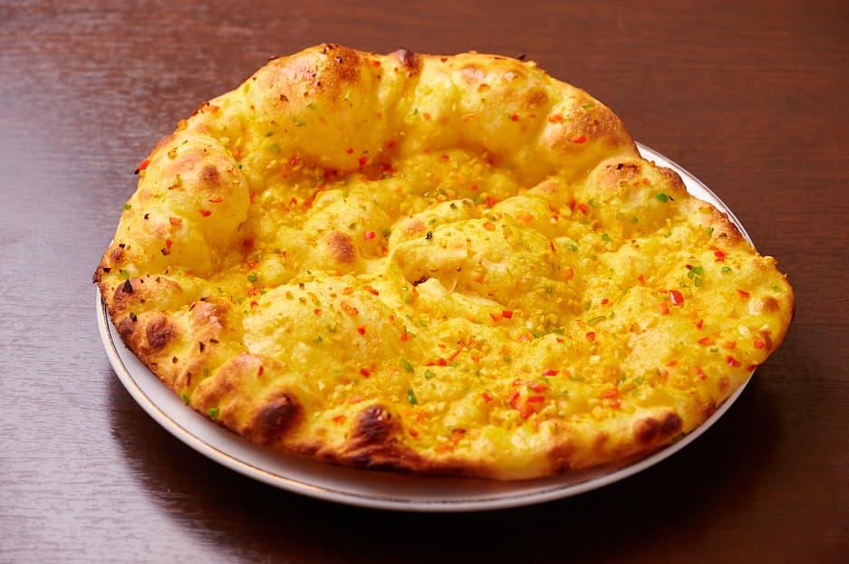 さくらアジアンダイニング&バーのこんがり溶けたチーズをのせた丸いナン