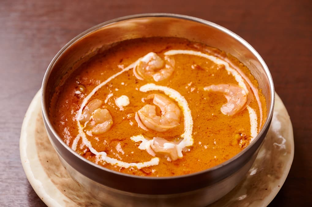 さくらアジアンダイニング&バーのクリームとカシューナッツを添えたオレンジ色のカレー