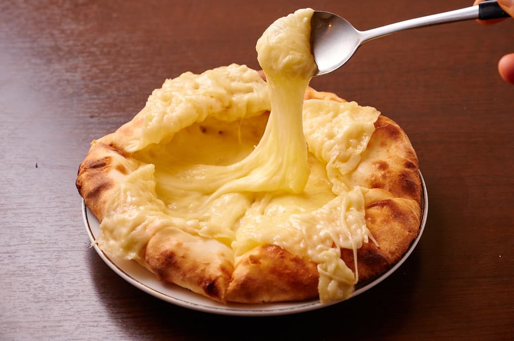 さくらアジアンダイニング&バーの溶けたチーズを持ち上げたチーズ入りナン