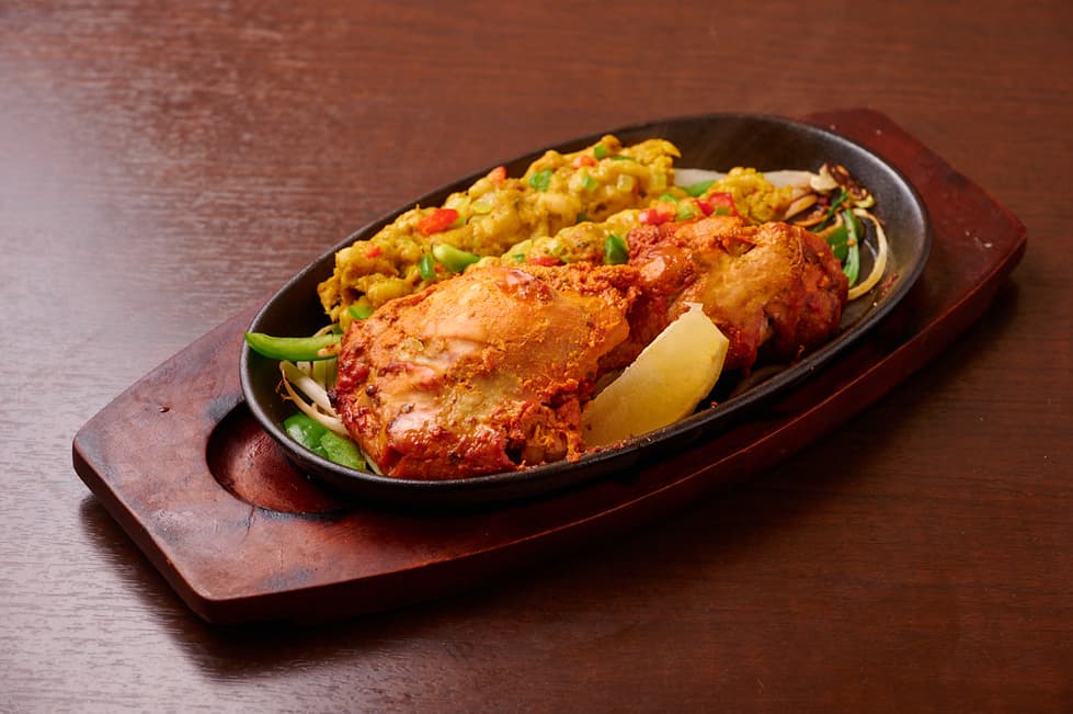 さくらアジアンダイニング&バーの野菜と一緒に鉄板で提供するタンドリーチキン