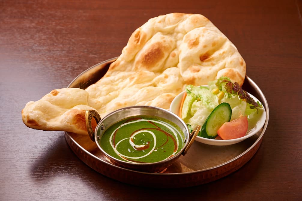 さくらアジアンダイニング&バーのほうれん草カレーとサラダを添えたナン